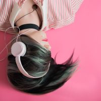 音频编辑在监听音箱前调整波形，桌面摆着耳机与笔记本，室内光线柔和